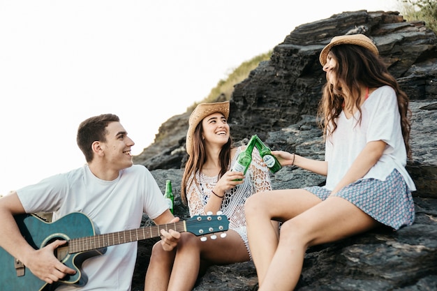 Happy friends at the beach with guitar