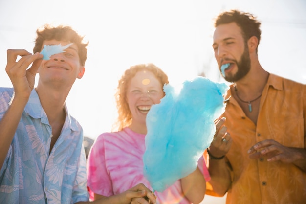 Happy friends enjoying together cotton candy