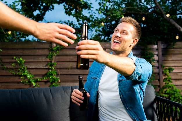 Happy friends exchanging beers