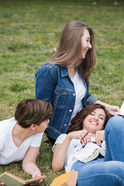 Happy friends laughing lying on grass