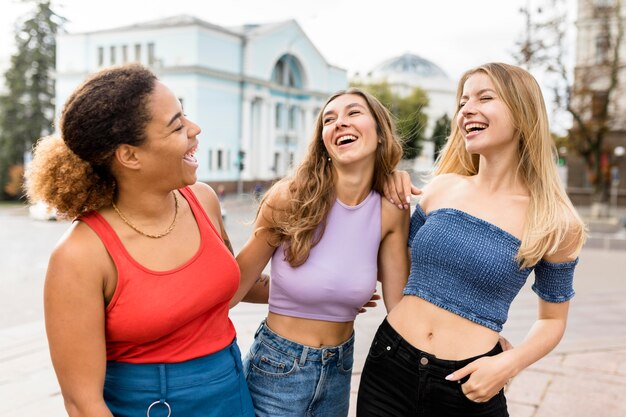 Happy friends laughing on the street front view