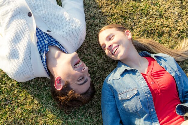 Happy friends lying on the grass and laughing