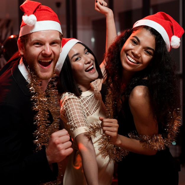 Amici felici che fanno festa con i cappelli di babbo natale