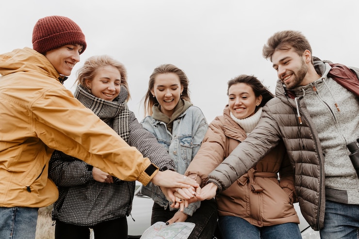 Free Photo happy friends putting hands together