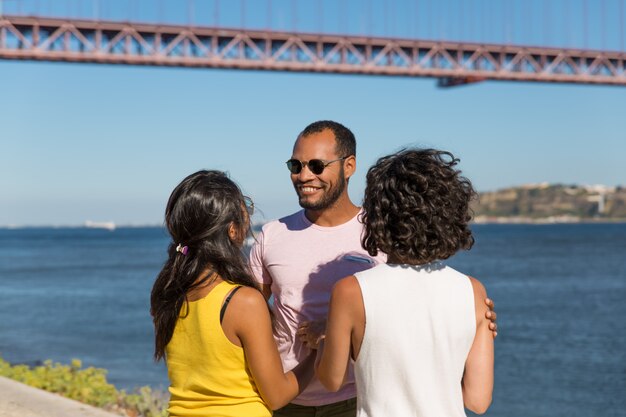 Happy friends standing near river