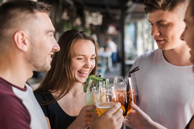 Happy friends toasting evening drinks at nightclub