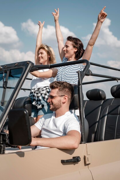 Happy friends traveling by car together