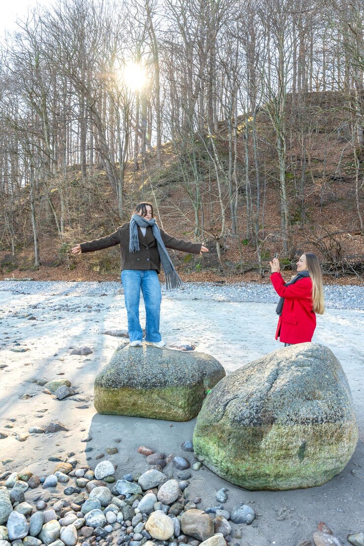 Free Photo happy friends walking by rock at beach two women on the rocks outdoors