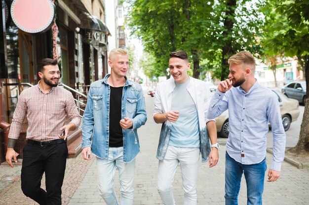 Happy friends walking together on pavement