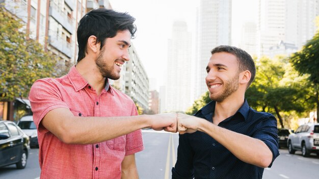 Happy gay couple greeting on street