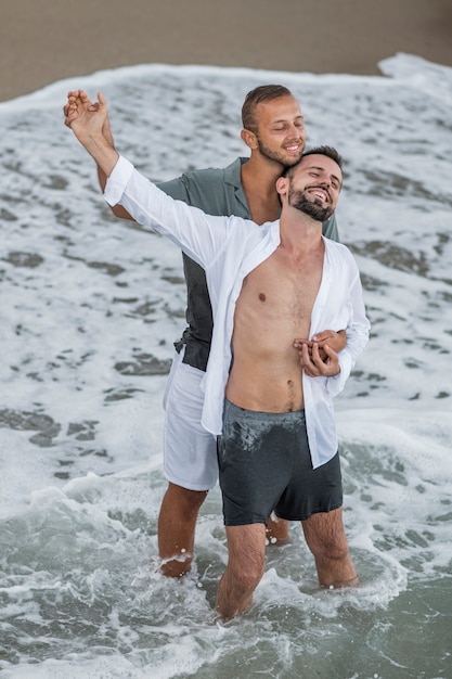 Счастливая пара геев на берегу моря