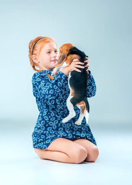 The happy girl and a beagle puppy