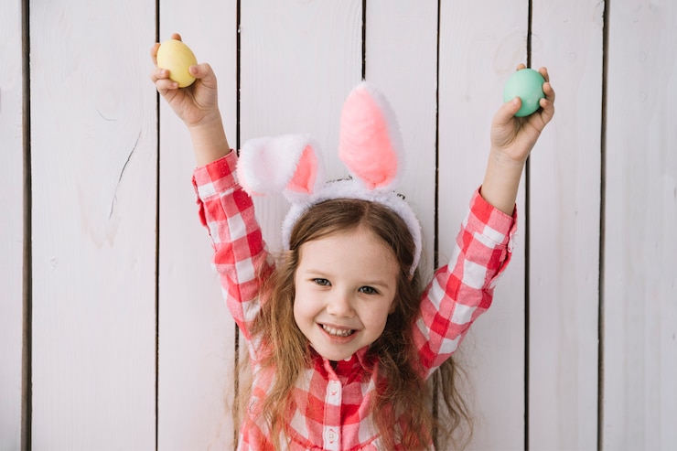 Free Photo happy girl in bunny ears with colored eggs in hands 