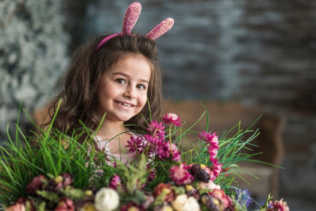 Happy girl in bunny ears with flowers