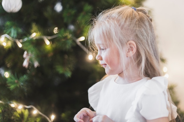 Happy girl next to christmas tree