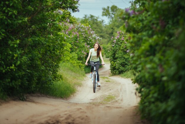 外のマウンテンバイクに乗っているハッピーガールサイクリスト。冒険旅行。