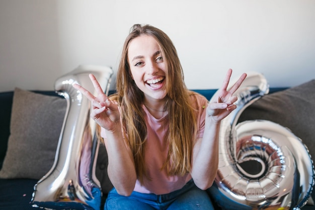 Free photo happy girl doing peace sign