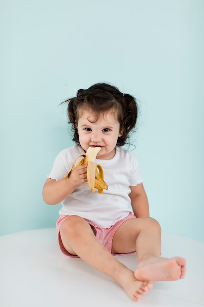 Happy girl eating a banana