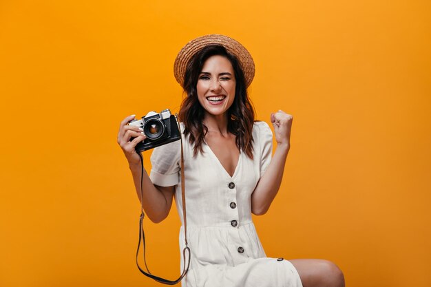 Happy girl in hat happily winks and holds camera
