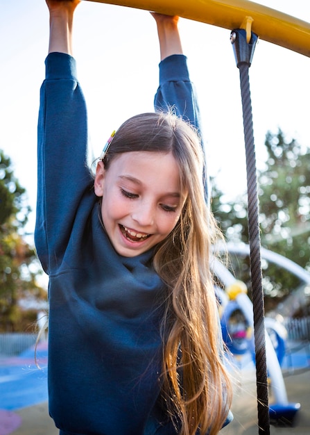 Happy girl having fun at the playground alone