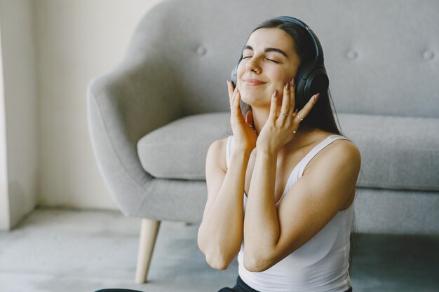 Foto gratuita la ragazza felice in cuffie ascolta la musica a casa