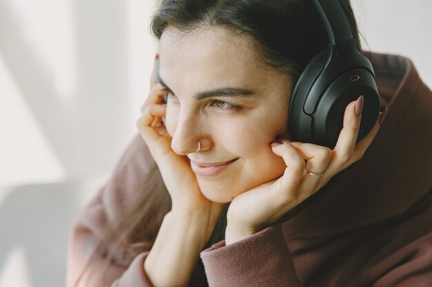 Happy girl in headphones listens to music at home