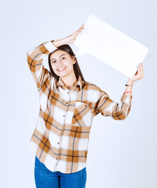  happy girl holding blank speech frame on white wall. 