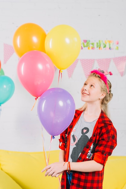 Happy girl holding colorful balloons