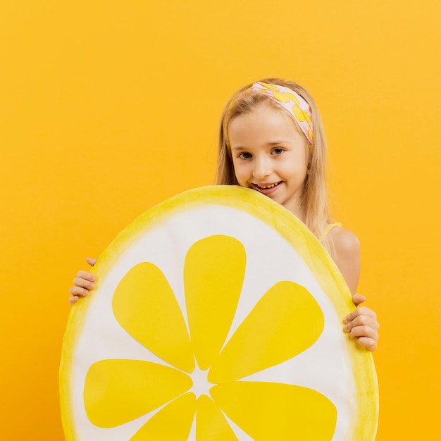 Free photo happy girl holding lemon slice decoration