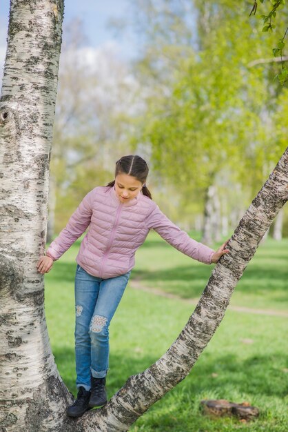 Happy girl playing on a tree