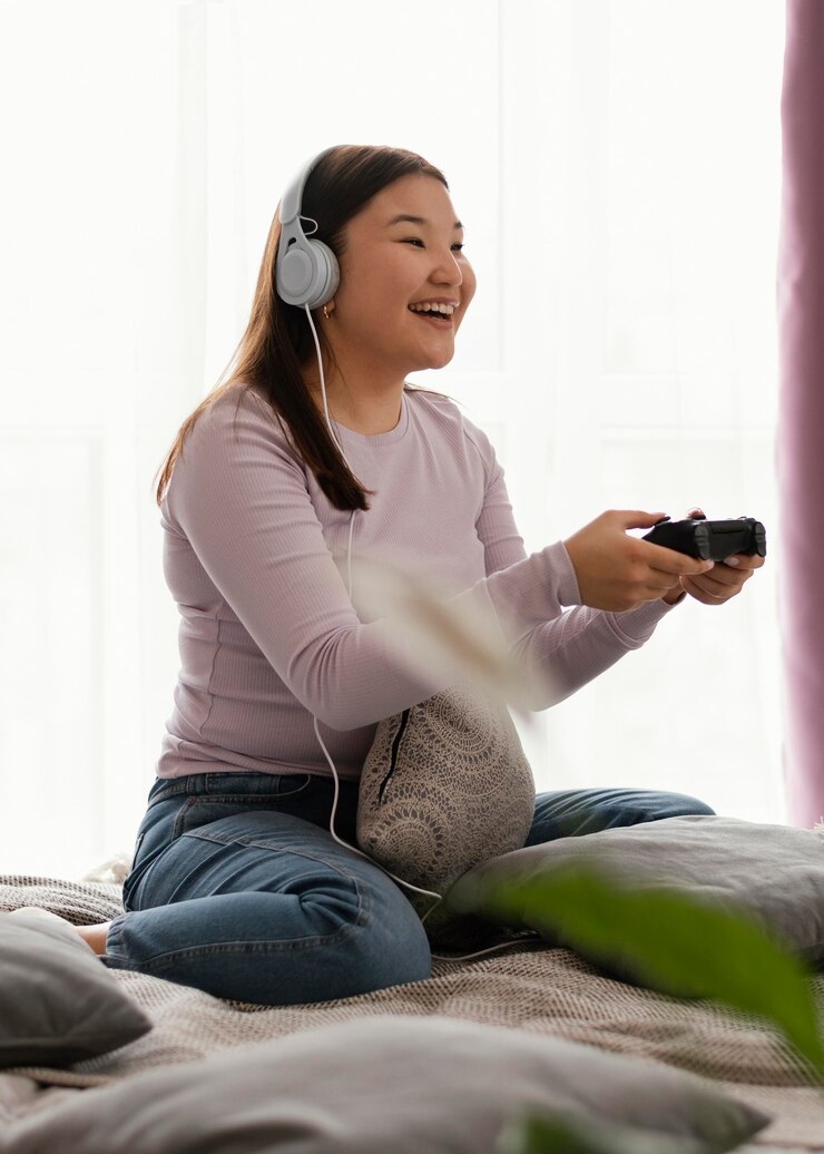 無料Photo ベッドでビデオゲームをしている幸せな女の子