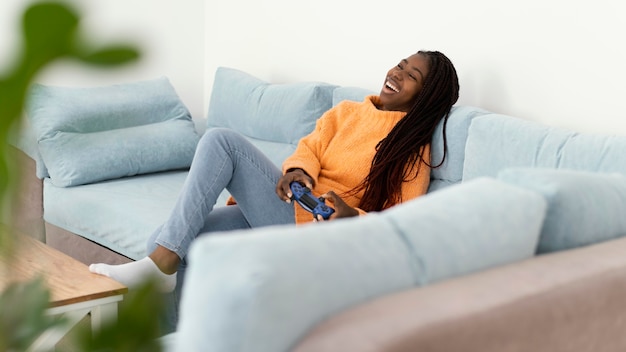 Happy girl playing videogame on couch