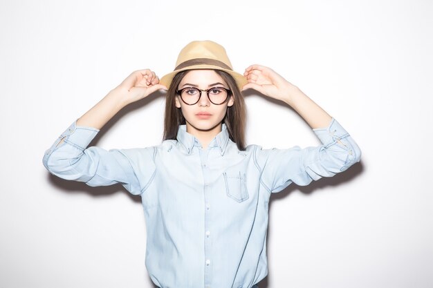 かわいいスタイリッシュな女の子は海のビーチを歩いてビキニで麦わら帽子をかぶっています 無料の写真