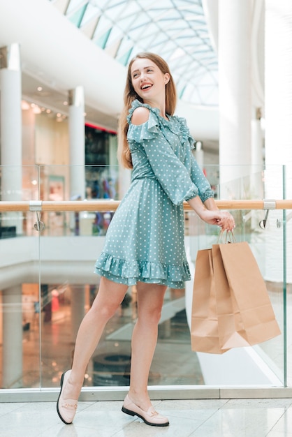 Счастливая девушка позирует в торговом центре