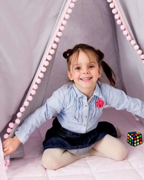 Happy girl posing in tent at home