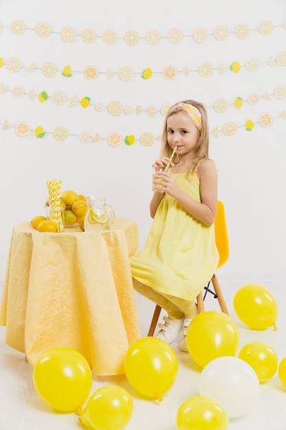 Счастливая девушка позирует держа стакан лимонада