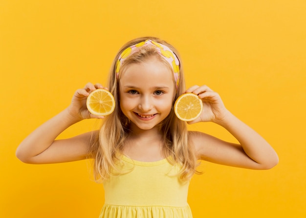 Счастливая девушка позирует с ломтиками лимона
