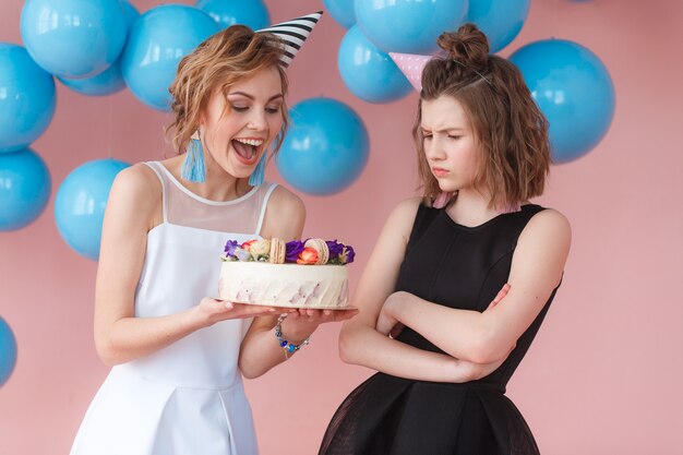 誕生日のケーキを探している幸せな少女と悲しい少女。二重性の概念