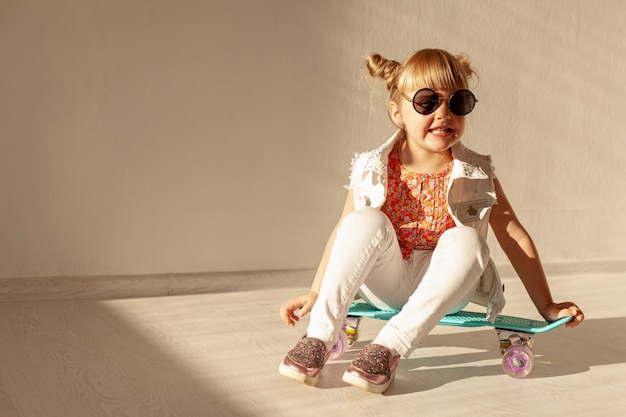 Happy girl sitting on skateboard