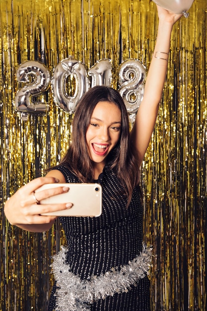 Free photo happy girl taking selfie on new year celebration