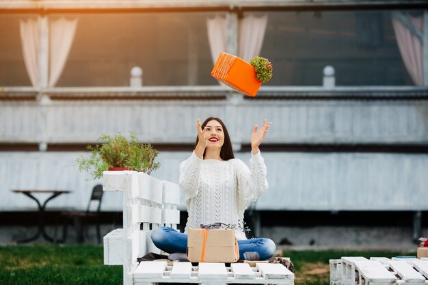 Happy girl throwing a gift upwards