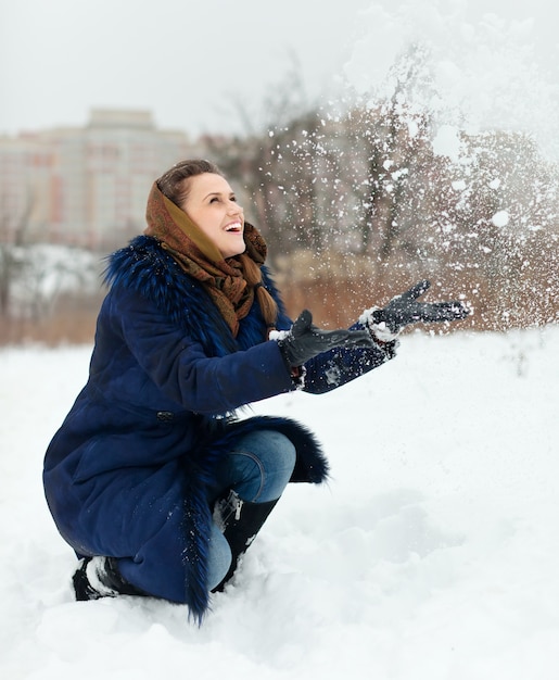 Foto gratuita ragazza felice che lancia i fiocchi di neve