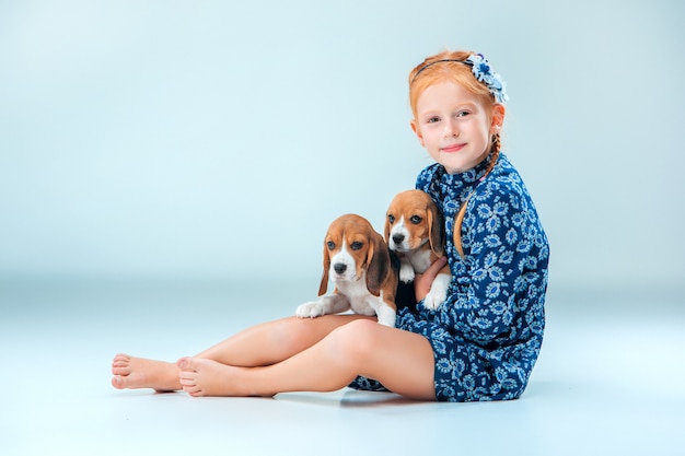 The happy girl and two beagle puppys