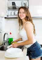 Free photo happy girl washing dishes