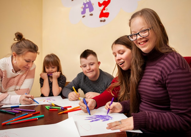 Free photo happy girl with down syndrome posing while drawing