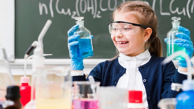 Free photo happy girl with goggles holding flasks