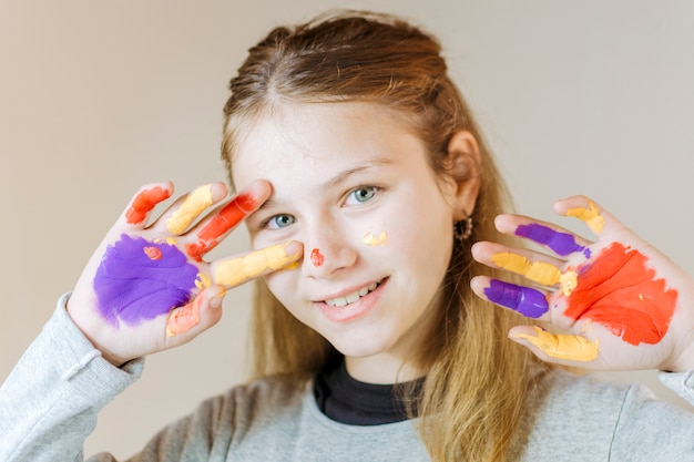 Happy girl with hands painted in watercolor paint