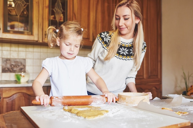 Happy girl with her mom dough