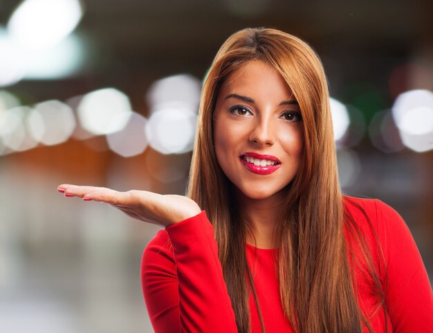 Happy girl with open hand palm on blurred background