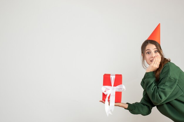 happy girl with party cap holding gift on white